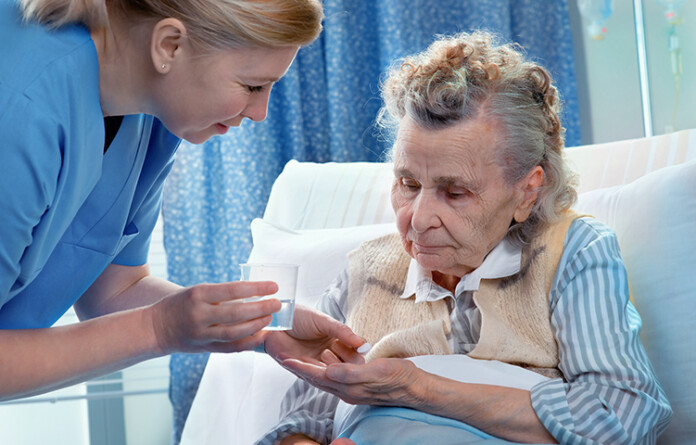 nurse gives a senior woman the medicine